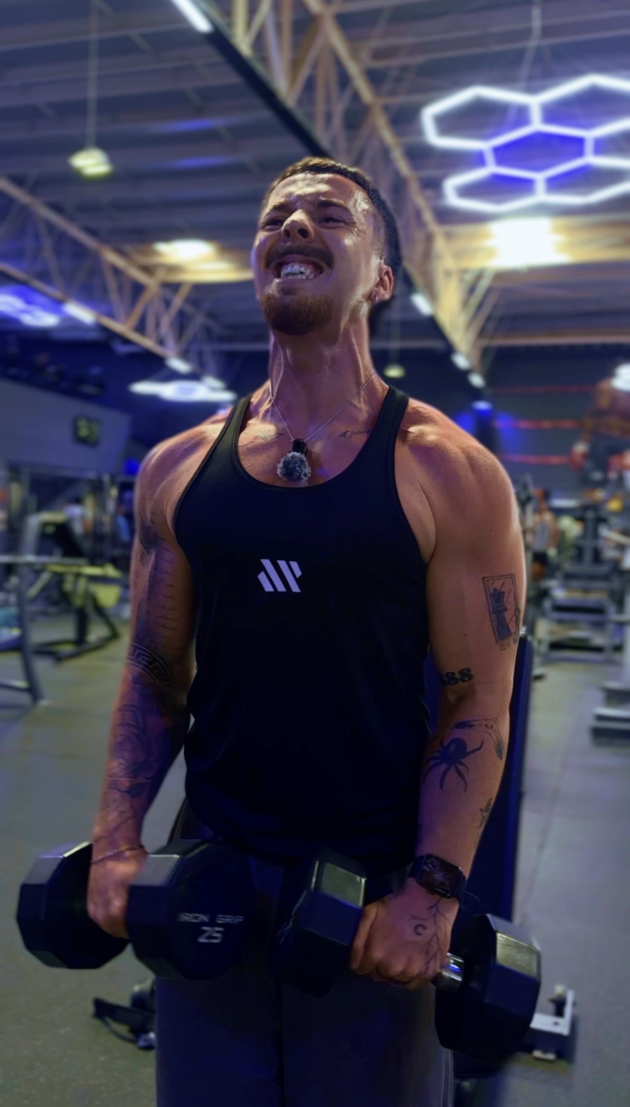 Jeremías Quintana sonriendo con mancuernas en el gym — coach fitness online